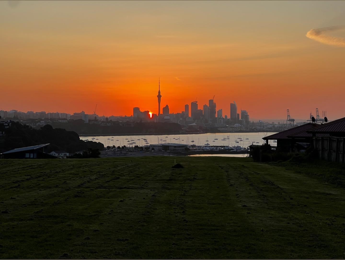 Sunset over the Auckland skyline and Sky Tower, viewed across the Waitematā from Ōkahu Bay